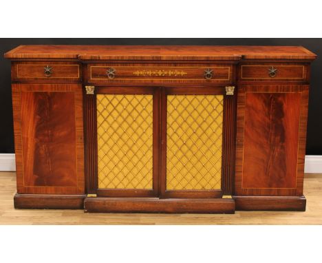 A Regency design break-centre sideboard, slightly oversailing top above three frieze drawers, and a pair of grilled doors enc
