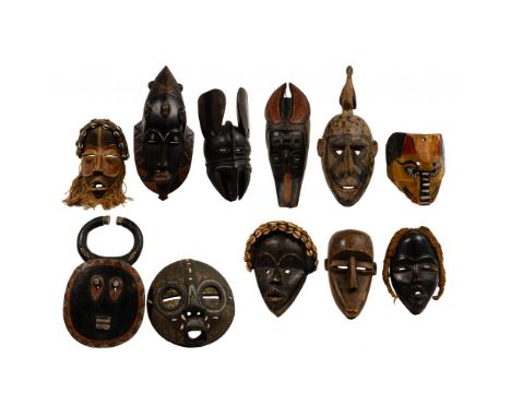 African Carved Wood Mask Assortment  (10) items including a painted Chokwe style having fiber and cowrie attachments; a coppe