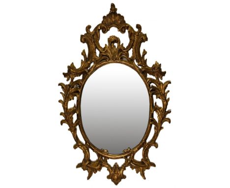 Rococo Style Wall Mirrors  Matched pair having oval beveled glass and ornately carved pierced gilt wood frames of foliate des