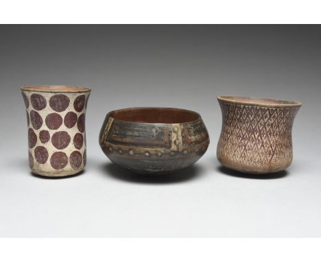 Three Peru vessels pottery, including a Moche beaker painted with a white ground and red spots, 11.5cm high, a waisted beaker