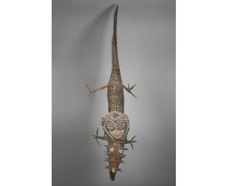 An Iatmul model crocodile Middle Sepik River, Papua New Guinea woven fibre with shell eyes and nose, with a carved bark ances
