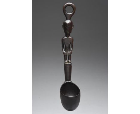 An Ifugao ladle Luzon Islands, Philippines with a standing male figure handle and a ring attachment surmount, 36cm long.