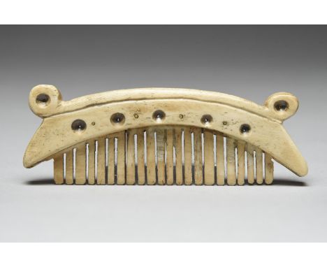 λAn Inuit comb Alaska marine ivory, with recessed circle decoration and brass pins, 11.5cm long.