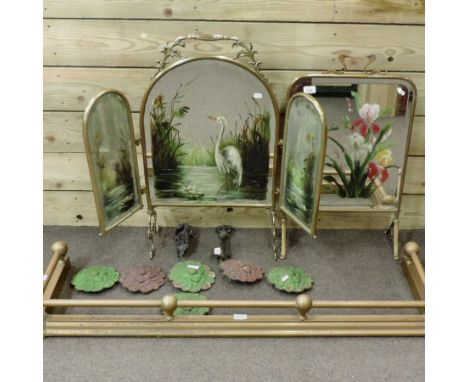 An early 20th century brass mirrored firescreen, 77cm tall, together with a collection of iron plaques, a screen and a fender