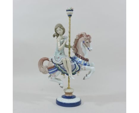 A Lladro figure of a girl on a merry-go-round, 40cm tall