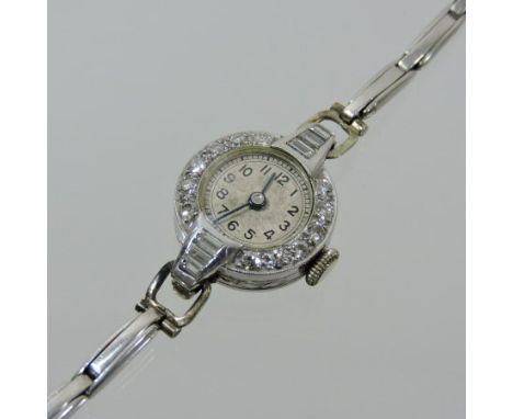 A 1920's platinum and diamond cased ladies cocktail watch, the Arabic dial surrounded by twelve stones, with three further to