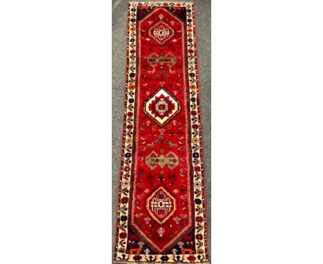 A South-west Persian Qashgai runner carpet, hand-knotted in rich colours, with five medallions, within a field of stylised bi