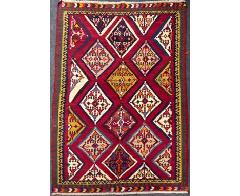 A South-west Persian Qashgai Kilim rug / carpet, hand-knotted with a field of diamond shapes, in tones of red, pale, and dark