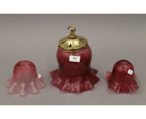 Three cranberry glass light shades. The largest 23.5 cm high overall.