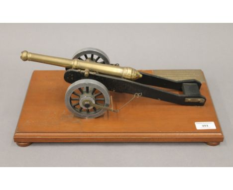 A model canon on a wooden plinth, with applied brass plaque inscribed ''Made by Rolls-Royce West Midlands Apprentices in Part