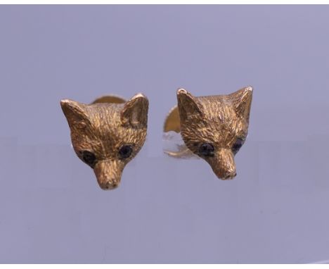 A pair of 9 ct gold ruby set fox mask ear studs, housed in a Garrard &amp; Co box. Each 7 mm wide. 2.3 grammes total weight.
