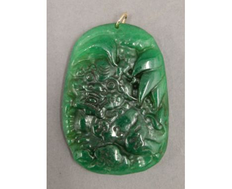 A gold mounted jade pendant. 6 cm high.