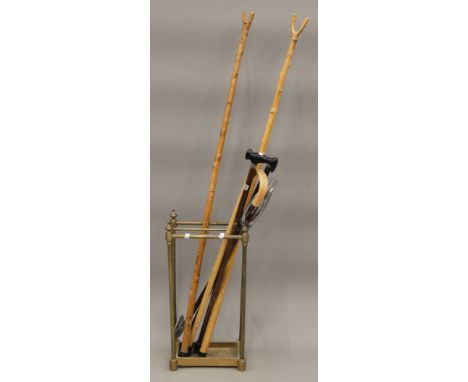 A Victorian brass stick stand and a collection of sticks. The former 62.5 cm high.