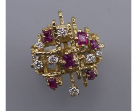 A Contemporary 18 ct gold ruby and diamond cluster ring. Ring size O. 14.2 grammes total weight.