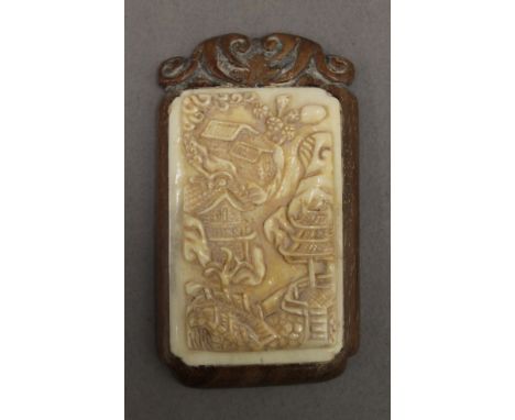 A Chinese bone and wooden plaque. 7 cm high.