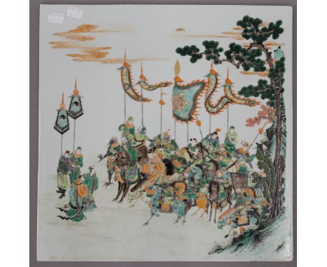 A Chinese famille verte porcelain plaque depicting warriors before battle. 40.5 cm wide.