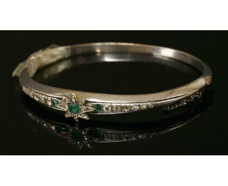 A Continental emerald and diamond set hinged bangle, with an applied emerald and diamond set star centrepiece. A cushion-shap