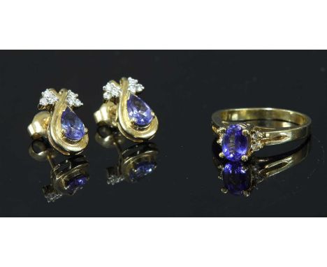 A gold tanzanite and diamond ring, with an oval mixed cut tanzanite, four claw set with a pair of brilliant cut diamonds claw