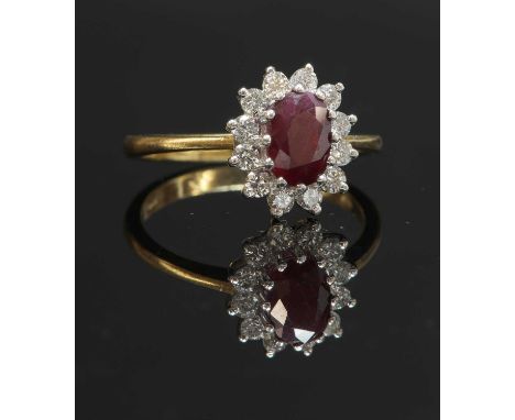An 18ct gold ruby and diamond oval cluster ring, with an oval mixed cut ruby, four claw set at the centre. A border of brilli
