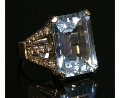 An 18ct white gold single stone aquamarine ring with diamond set shoulders, with an emerald cut aquamarine, four claw set in 