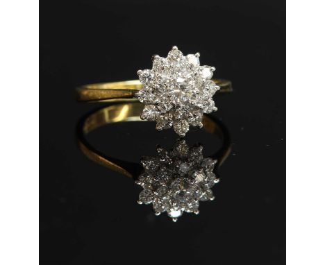 An 18ct gold three-tier diamond cluster ring, with a brilliant cut diamond, claw set to the centre. Two stepped tiers of grad