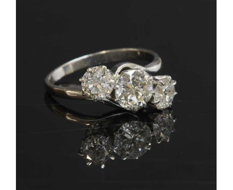 A platinum three stone diamond crossover ring, with a brilliant cut diamond, estimated as approximately 0.85ct. A smaller bri