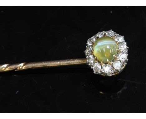 A cased Edwardian chrysoberyl cat's eye and diamond cluster stick pin/dress stud, an oval cabochon chrysoberyl cat's eye, cla