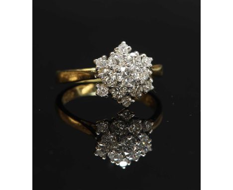 A two colour gold diamond set snowflake cluster ring, with a brilliant cut diamond, claw set to the centre. A border of brill