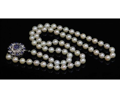 A single row uniform cultured pearl necklace, with a sapphire and diamond circular cluster clasp. A row of sixty-six cultured