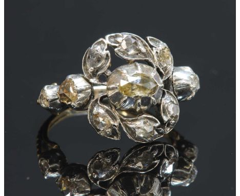 A late Georgian giardinetti silver and gold ring, with an oval rose cut diamond, in a cut down collet at the centre. An outer