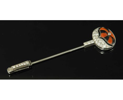 An Art Deco platinum, coral, black paste and diamond set jockey cap jabot or stick pin, c.1925, the jockey cap with colours d