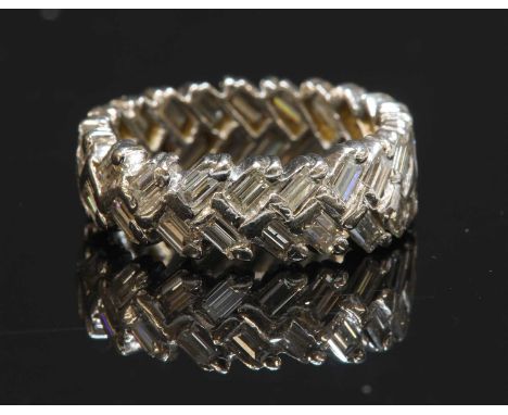 A white gold diamond set band ring, with two rows of baguette cut diamonds, claw set in a chevron or herringbone design. Test