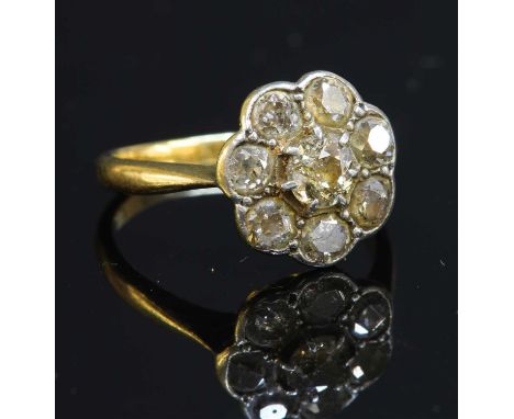 A gold diamond cluster ring, with an old cut diamond six claw set to the centre, to a border of mixed old cut diamonds, grain