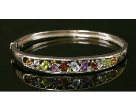 A 9ct white gold gemstone and diamond hinged bangle, with a graduated open top section, scattered gemstones to include garnet