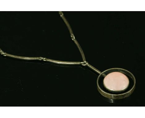 A Danish sterling silver rose quartz necklace, c.1960, by Niels Erik From. A circular cabochon rose quartz, rub set in a plai