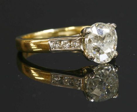 An 18ct gold single stone diamond ring, with diamond set shoulders. An old European cut diamond, estimated as approximately 1