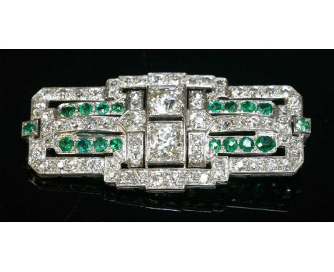 An Art Deco emerald and diamond plaque brooch, c.1925, of stepped rectangular form. Two principal old brilliant cut diamonds,