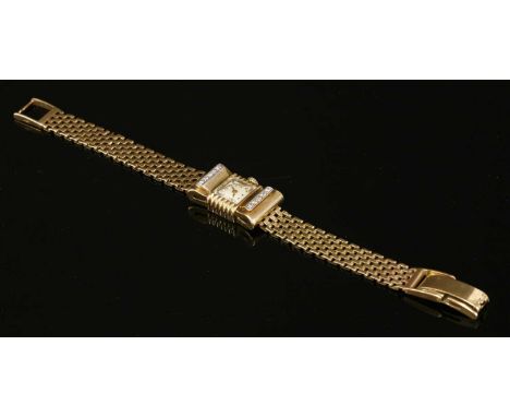 A ladies' 9ct gold, diamond set mechanical cocktail watch, c.1945-1955, of stylised bow form. A square silvered dial with gil