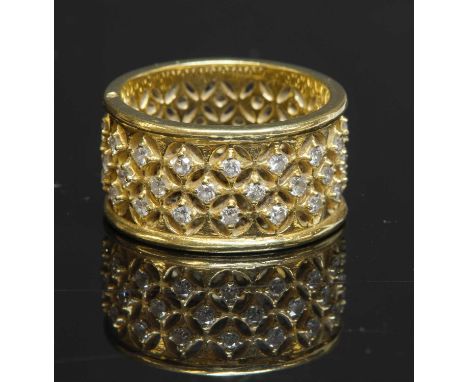 A gold diamond set flat section band ring, with a pierced lattice effect ground. Three rows of brilliant cut diamonds, all fo