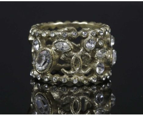 A Chanel paste set ring, the openwork band with oval, marquise and round faceted paste and double 'C' logos, to border of rou