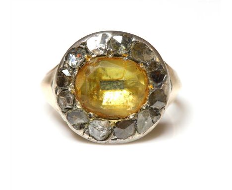 A Georgian foiled citrine and diamond cluster, later mounted as a ring. An oval mixed cut foiled citrine, claw set to a borde