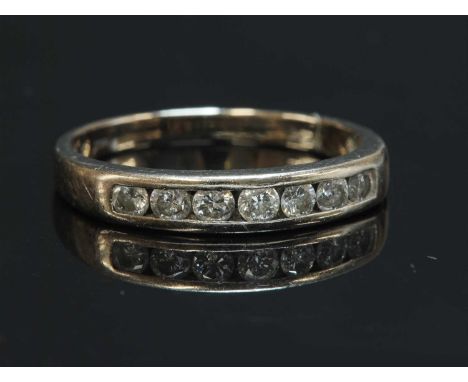 An 18ct white gold diamond set half eternity ring, with seven brilliant cut diamonds, channel set to a flat section head with