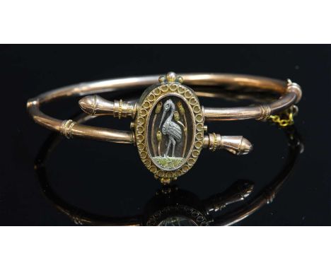 A late Victorian Aesthetic Movement crossover hinged bangle, with a Japanese shakudo-style plaque to the centre. An oval plaq
