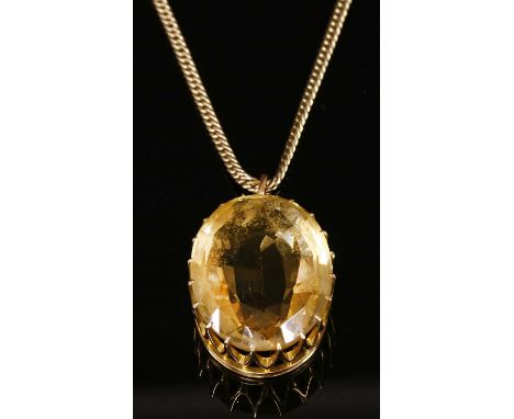 A single stone gold citrine pendant, with an oval Brazilian cut citrine, claw set to an oval rex collet, with a later gilt me