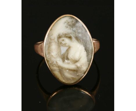 A Georgian gold memorial ring, with a navette-shaped painted panel beneath a glazed cover. A classical lady with an urn, pain