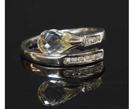 A 14ct white gold rock crystal and diamond crossover ring, with a rock crystal briolette, set to a fluted cap. A crossover sh