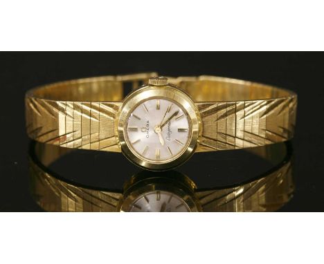 An 18ct gold ladies' Omega Ladymatic automatic bracelet watch, the circular case, 18mm diameter with silvered dial, raised gi