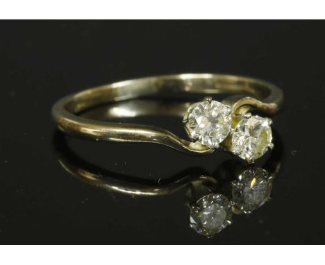 A two stone crossover ring, with two brilliant cut diamonds, estimated as approximately 0.30ct each, claw set in rex collets 