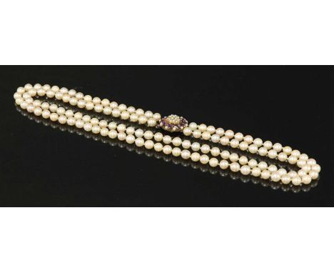 A two row uniform cultured pearl necklace, with an amethyst cluster clasp. Two rows of uniform cultured pearls, 8 to 8.5mm in