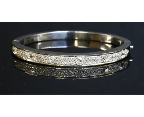 A flat section diamond set hinged bangle, with six cushion cut and old European cut diamonds, grain set between sections of p
